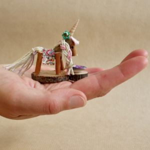 Naturmake model of a tiny unicorn in the palm of a hand